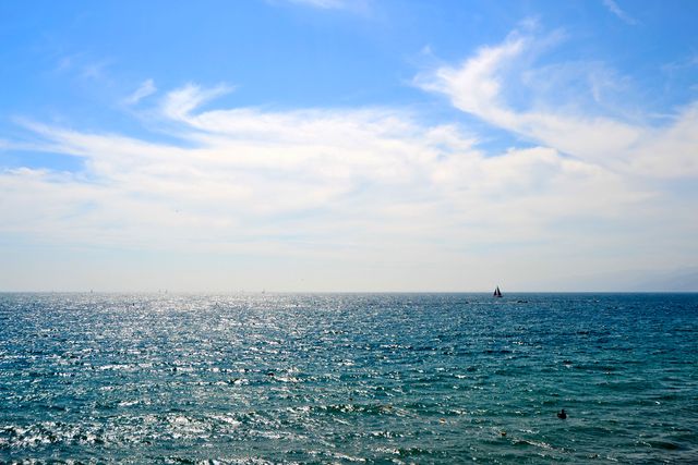Serene Ocean View with Sailboat under Bright Sky - Download Free Stock Photos Pikwizard.com