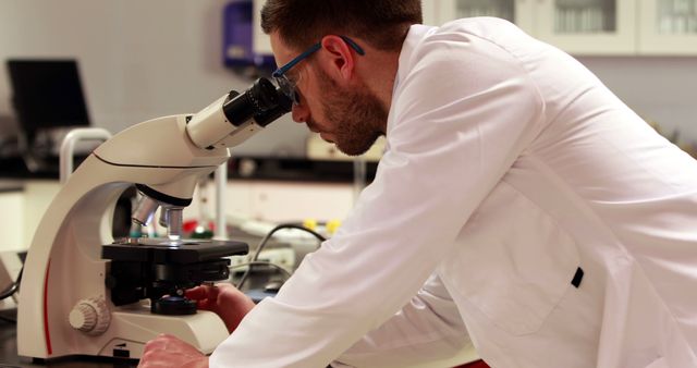 Focused Scientist in Lab Coat Using Microscope in Laboratory - Download Free Stock Images Pikwizard.com