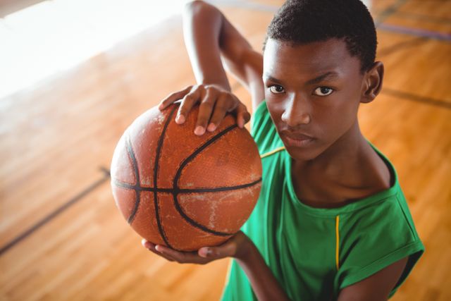 Focused Teenager Holding Basketball on Court - Download Free Stock Photos Pikwizard.com