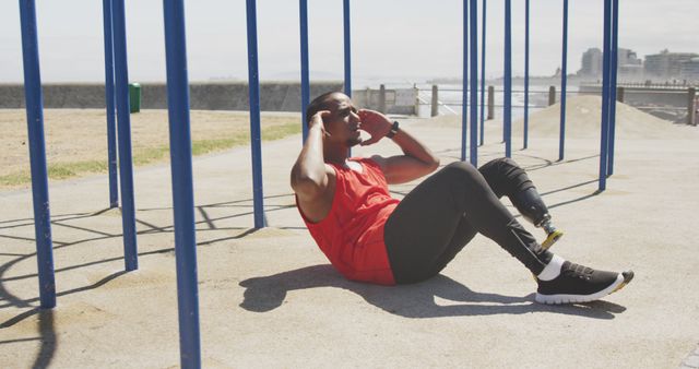 Young man doing sit-ups at outdoor fitness park - Download Free Stock Images Pikwizard.com