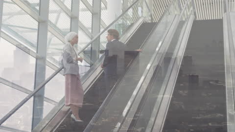 Business Colleagues Conversing on Modern Escalator above Cityscape