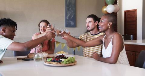 Friends Celebrating with Toast and Snacks at Home Party