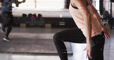 Female athlete balancing and lifting knee in gym with augmented reality overlays