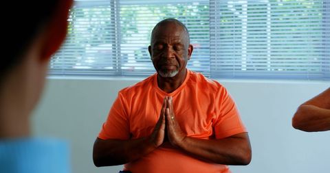 Senior African American Man Meditating During Yoga Class