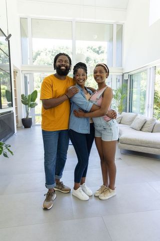 Smiling family hugging in bright modern open-plan living room