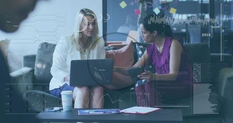 Mature women reviewing data on laptop and tablet, collaborating on analytics