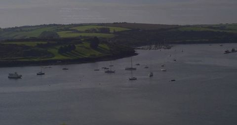 Calm estuary with anchored sailboats and yachts in scenic harbor