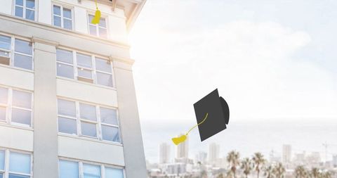 Graduation caps soaring against urban cityscape backdrop