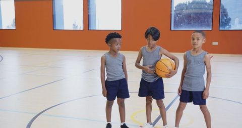 Boys Practicing Basketball in School Gym Reflecting Youth Athletics