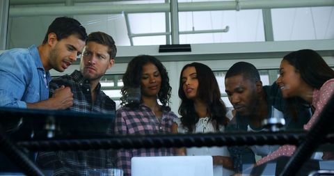 Diverse Team Collaborating on Project Around Laptop in Office