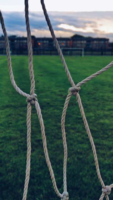 Close-Up View of Soccer Net Against Green Field at Dusk - Download Free Stock Images Pikwizard.com