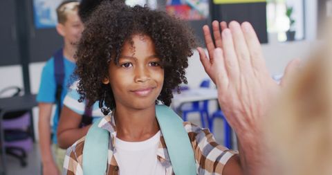 Happy Schoolchild High-Fiving Teacher in Classroom - Download Free Stock Images Pikwizard.com