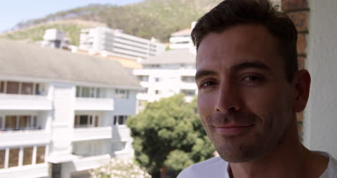 Smiling Man Enjoying Sunny Day on Balcony