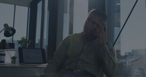 Mature Professional on Phone in Urban Open-Plan Office Environment