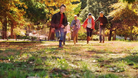 Happy Family Running Through Autumn Park