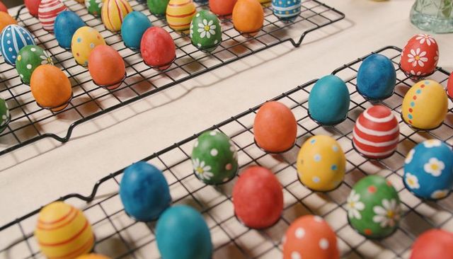 Hand-decorated easter eggs drying on wire racks colorful painted spring diy display