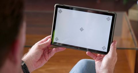Man relaxing with tablet displaying expert mode interface at home