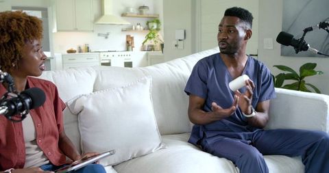 Home podcast interview featuring healthcare professional in scrubs and cohost recording
