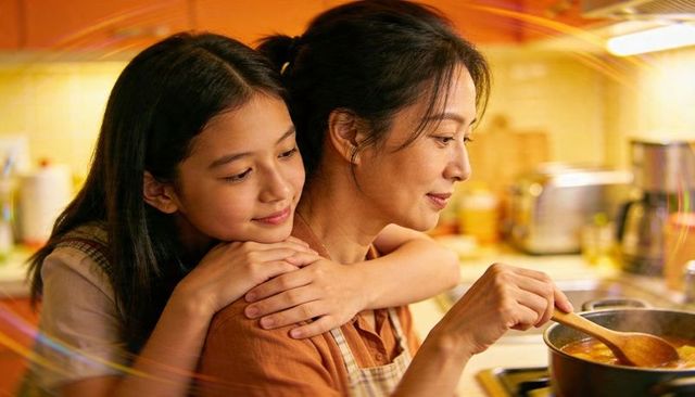 Mother and daughter cooking together, daughter hugging while mom stirs soup in cozy kitchen