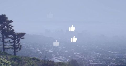 Floating thumbs-up icons over foggy hillside neighborhood showing social media engagement