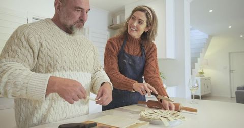 Happy Couple Preparing Homemade Pie in Modern Kitchen