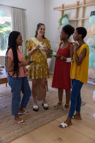 Joyful Female Friends Celebrating with Tea and Laughter