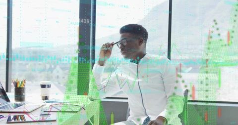 Businessman Analyzing Data with Futuristic Digital Charts in Office