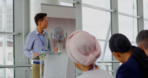 Asian male speaker delivering seminar at business conference