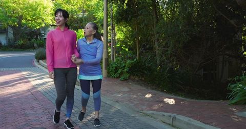 Mother and Daughter Walking in Tranquil Garden Pathway