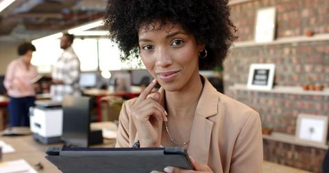 Confident businesswoman using tablet in modern office.
