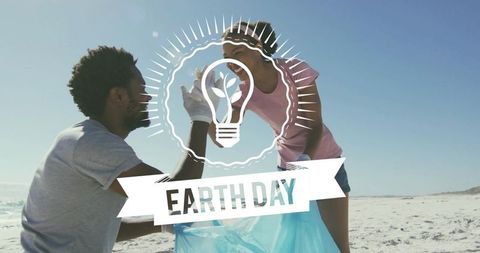 Earth day beach cleanup eco volunteers collecting litter on sandy shoreline with blue bag