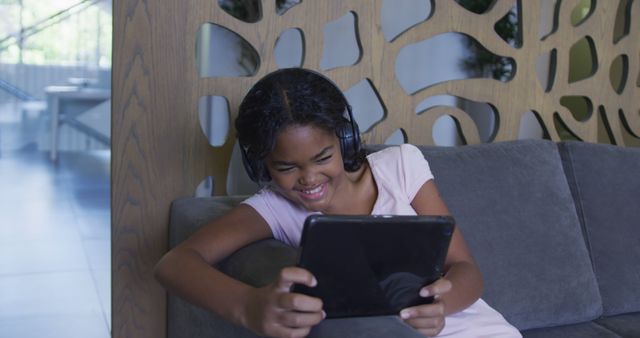 Smiling Girl Using Tablet on Couch with Headphones in Hospital - Download Free Stock Images Pikwizard.com