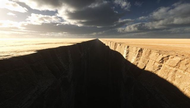 Endless desert chasm stretching to horizon with layered rock faces and dramatic shadows