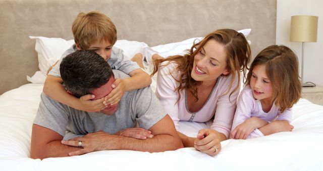 Happy Family Relaxing and Playing on Bed at Home - Download Free Stock Images Pikwizard.com