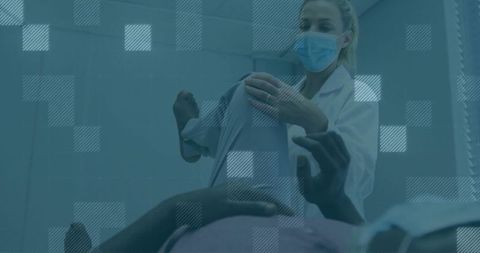 Masked clinician assessing patient's joint mobility with care