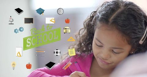 Elementary student writing at desk with colorful back to school graphics and banner