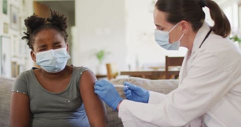 Doctor Administering Vaccine to Child at Home During Pandemic