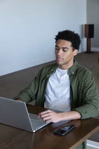 Focused man working on laptop in minimalist workspace