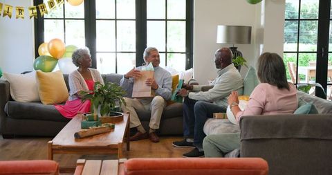 Senior Friends Celebrating Birthday with Gifts in Living Room