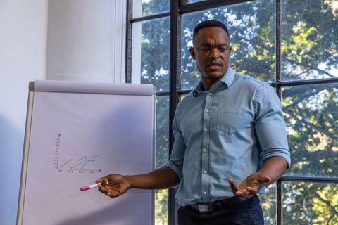 Man Analyzing Graph in Office Environment