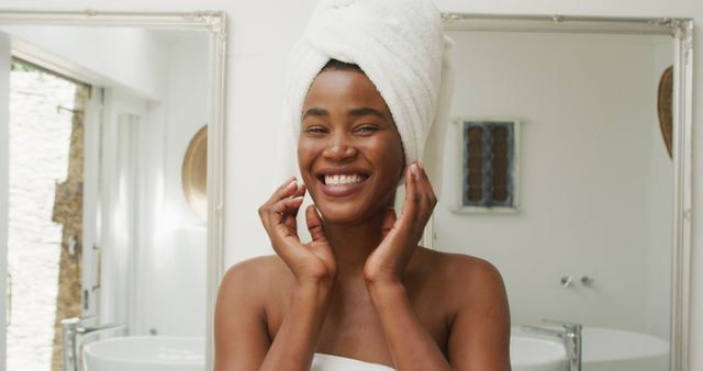 Image of happy african american woman in robe smiling at camera. beauty treatment and skin care routine concept.