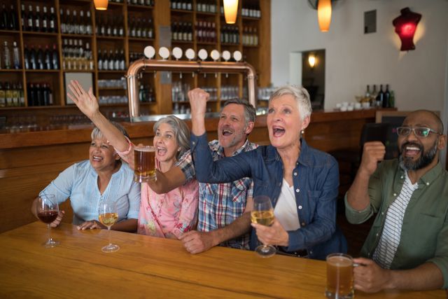 Group of friends sitting together in a bar, enthusiastically watching a soccer match on TV. They are cheering and celebrating with drinks in hand. Ideal for use in advertisements for sports bars, social gatherings, or senior activities. Perfect for illustrating themes of friendship, excitement, and community.