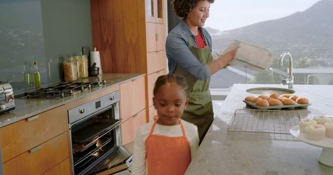 Mother and Daughter Baking Buns in Modern Kitchen