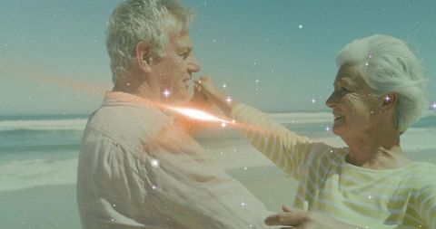 Senior Couple Dancing on Beach with Glittering Sparkles
