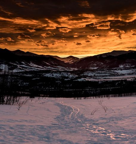 Dramatic winter sunset over snow-covered mountain landscape