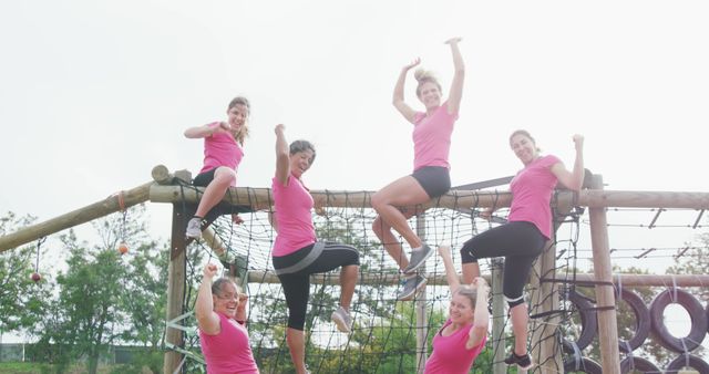 Happy caucasian female friends in pink t shirts celebrating on climbing frame at bootcamp - Download Free Stock Photos Pikwizard.com