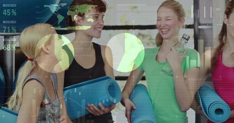 Women smiling and holding yoga mats with fitness data overlay in gym studio
