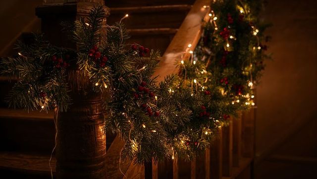 Cozy Christmas Garland Draping Along Rustic Wooden Staircase Banister with Warm Lights