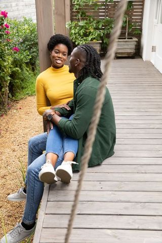 Smiling Couple Relaxing on Outdoor Deck Surrounded by Nature
