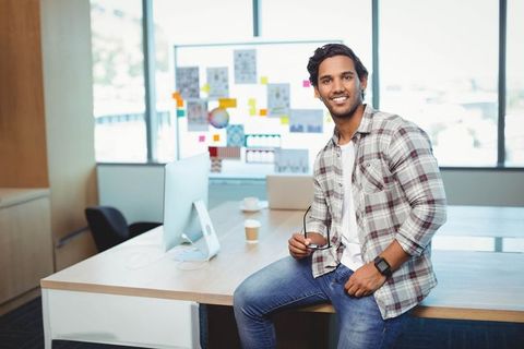 Confident Professional Evaluating Charts in Modern Office Workspace